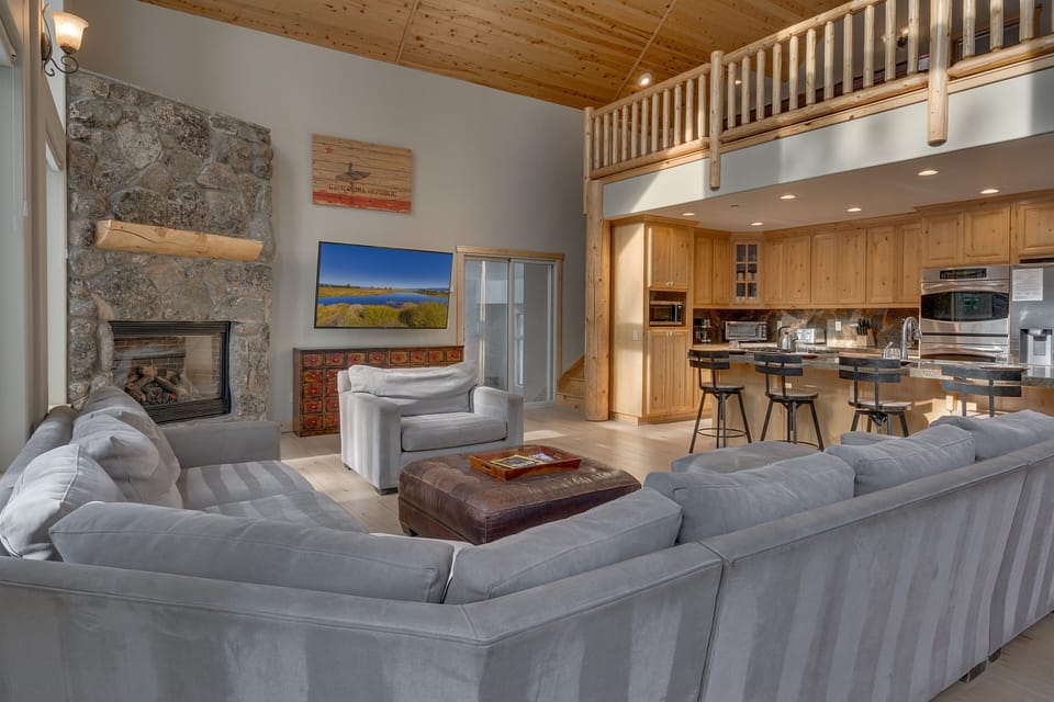 - Open living area with fireplace and vaulted wood ceilings  
- Spacious layout flows into the fully equipped kitchen  
- Comfortable sectional perfect for family gatherings
