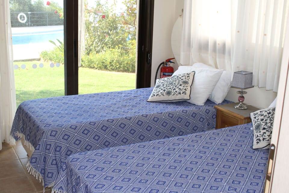 Twin bedroom with air conditioning and ceiling fan