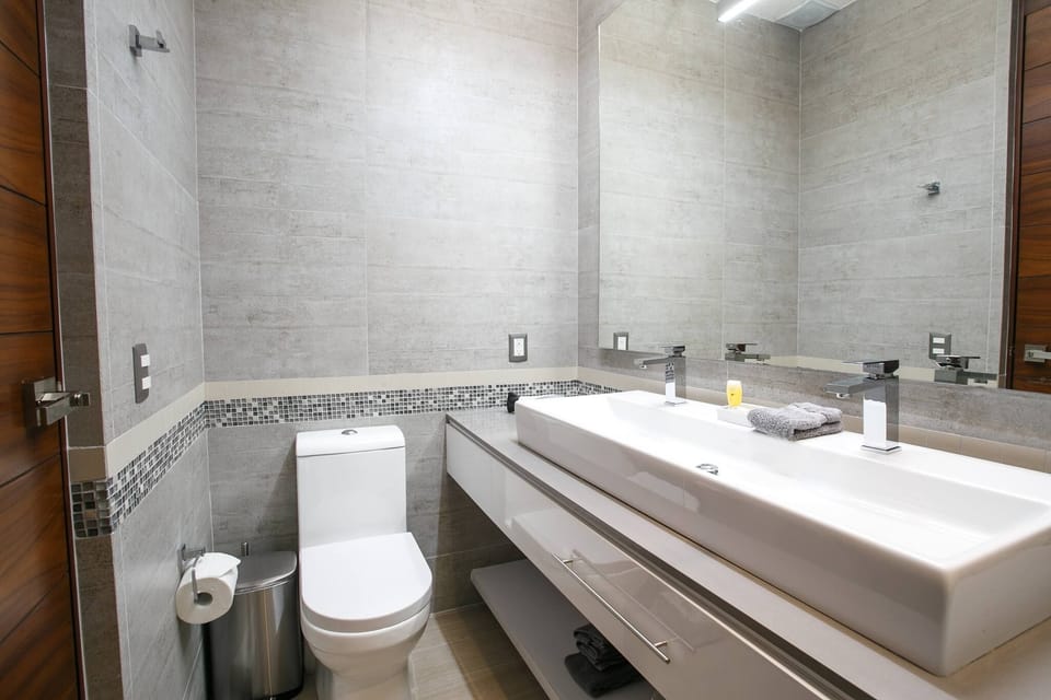 Full ensuite bathroom with dual faucet sink