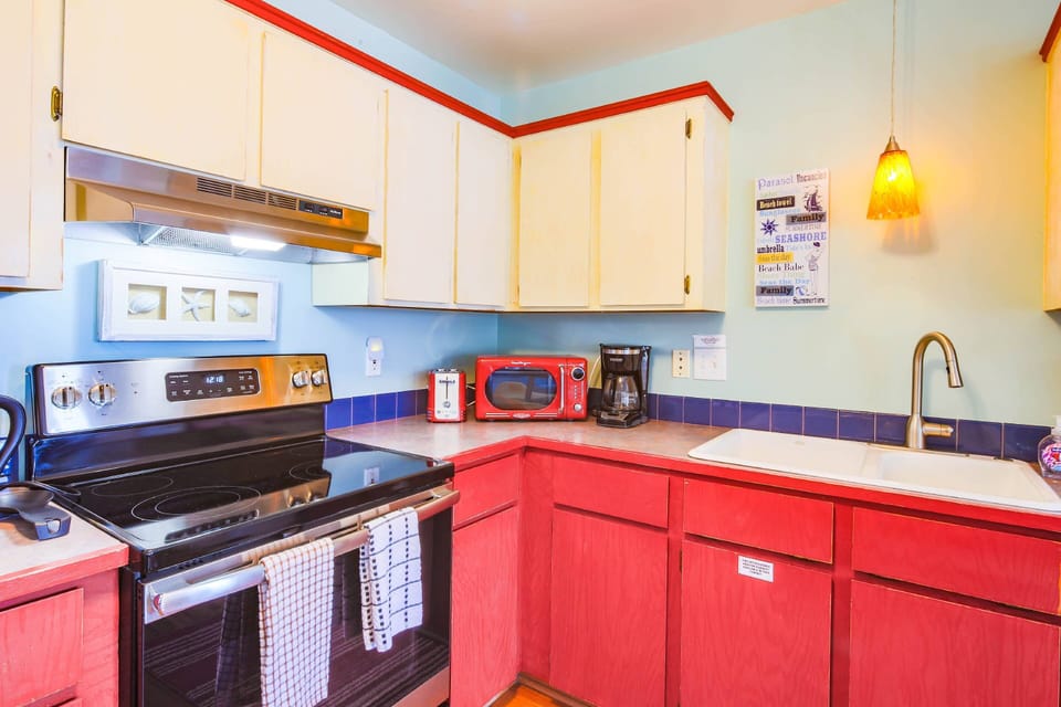 The kitchen features an electric range, microwave, drip coffee maker and toaster.