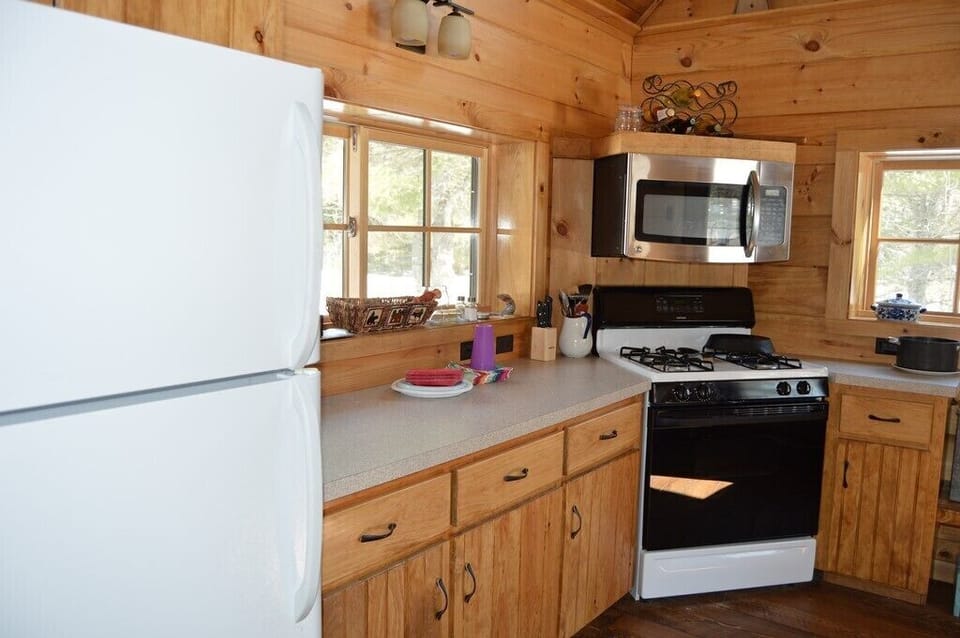 Kitchen view of microwave, stove and refrigerator/freezer