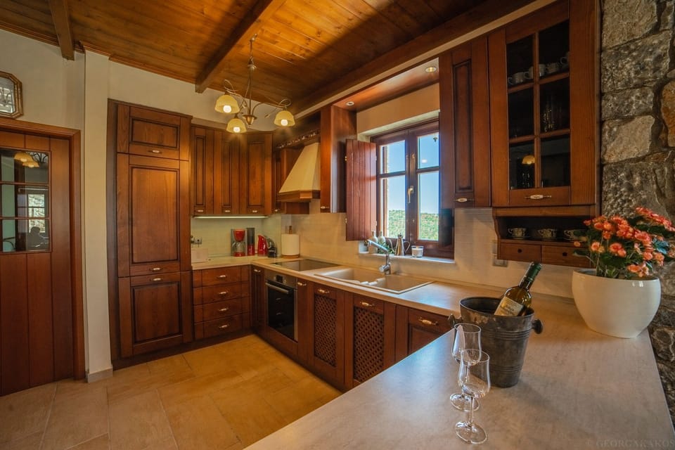 Traditional first-floor living room with stone walls, wooden roof, fireplace, dining room, kitchen, and toilet.