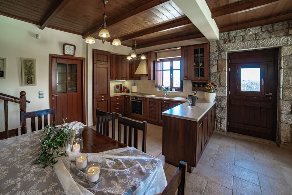 Traditional first-floor living room with stone walls, wooden roof, fireplace, dining room, kitchen, and toilet.