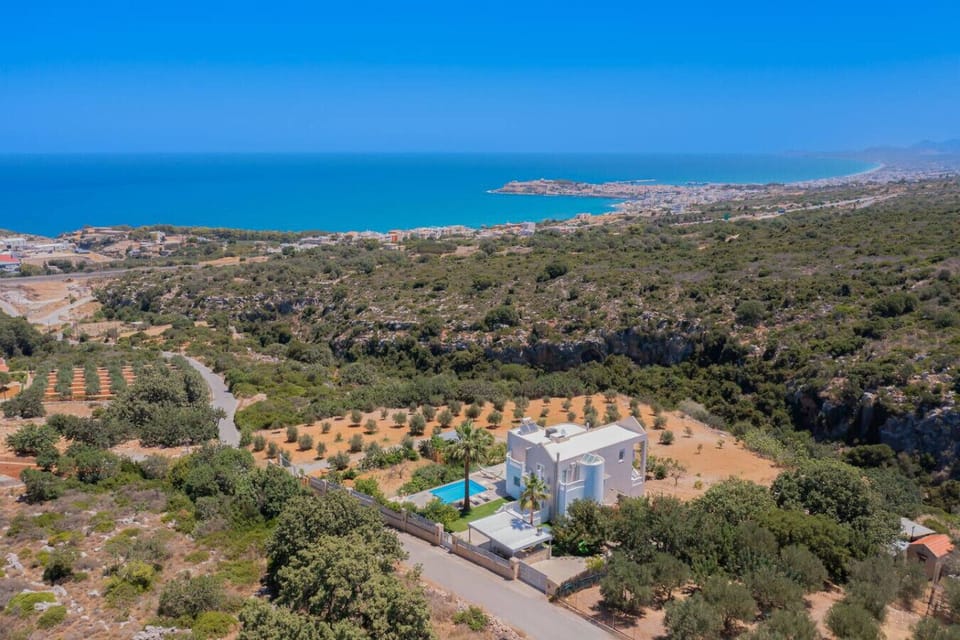 A serene outdoor space with views of the pool below and the sea beyond.