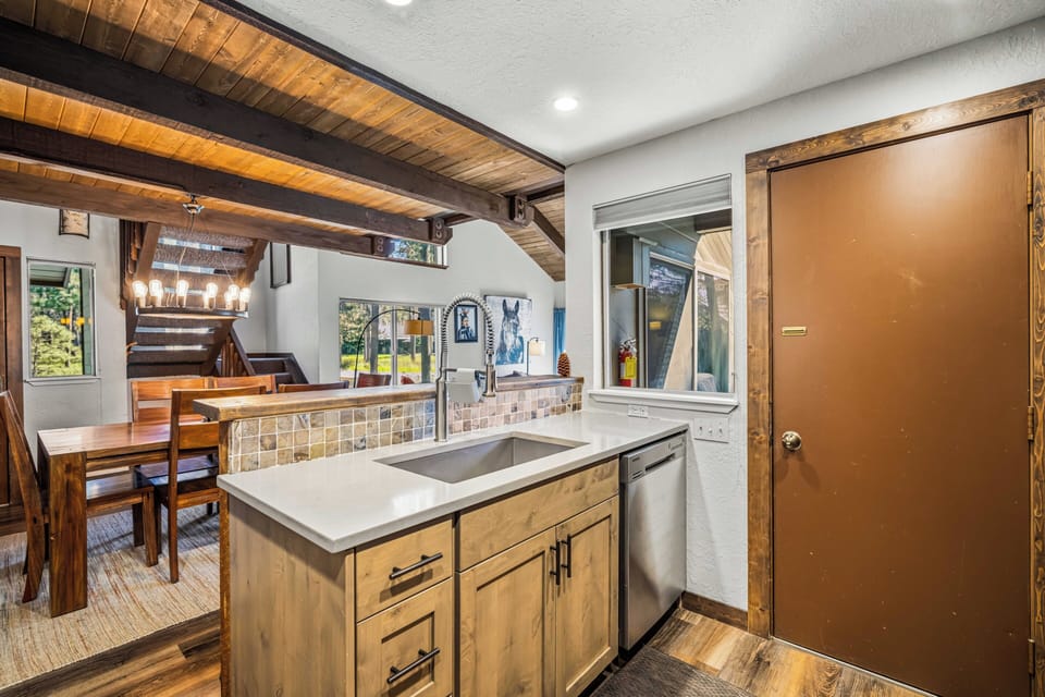Step into your rustic mountain retreat, where exposed beams meet modern convenience—your fully equipped kitchen flows into a warm dining space, ready for home-cooked meals and cozy gatherings.