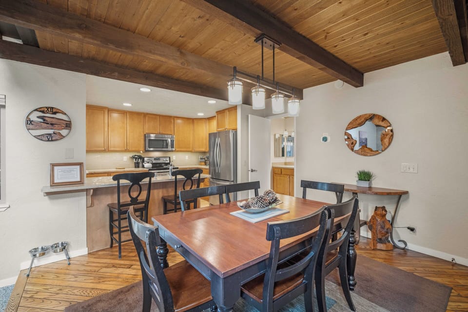 Gather around the spacious dining table under warm wood-beam ceilings, with the full kitchen ready for your meals and memories together.