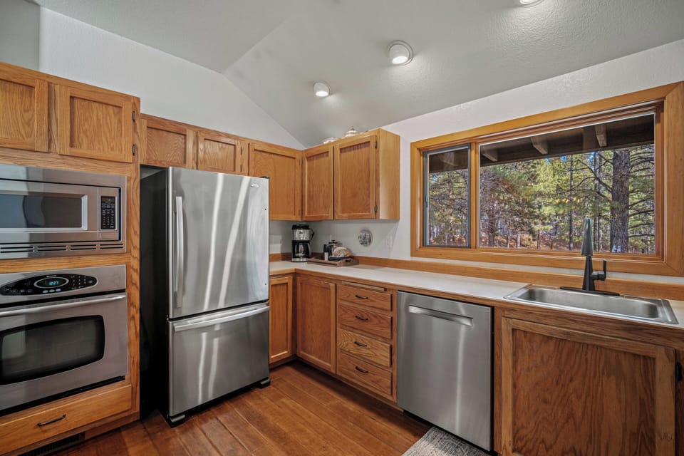 Cook your favorite meals in this fully equipped kitchen with stainless steel appliances and peaceful forest views through the large window.
