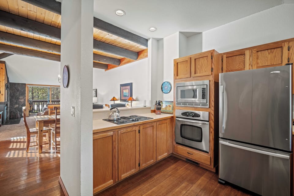 Step into your fully equipped kitchen with stainless steel appliances, warm wood cabinets, and everything you need to cook.