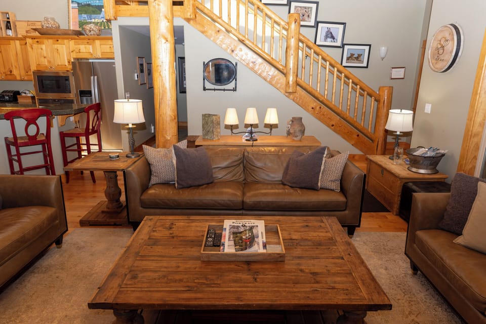 Sink into rich leather sofas in your rustic living room, where warm wood accents and soft lamplight create the perfect mountain retreat.