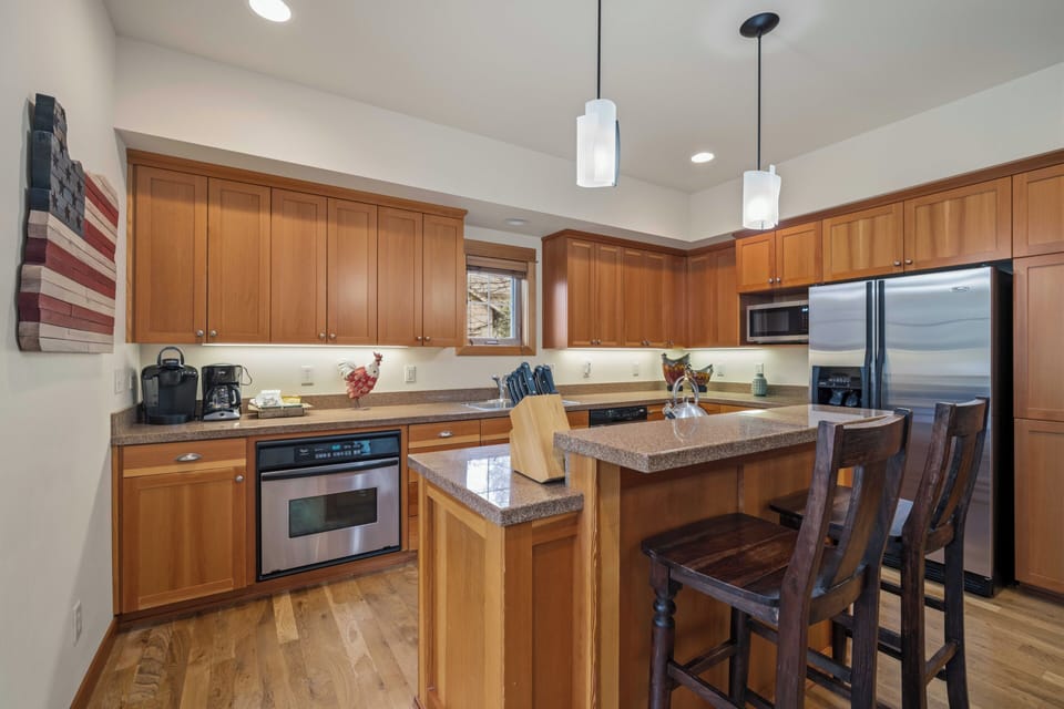 Your fully equipped kitchen awaits with warm wood cabinets, granite counters, and stainless appliances—perfect for preparing memorable meals together.