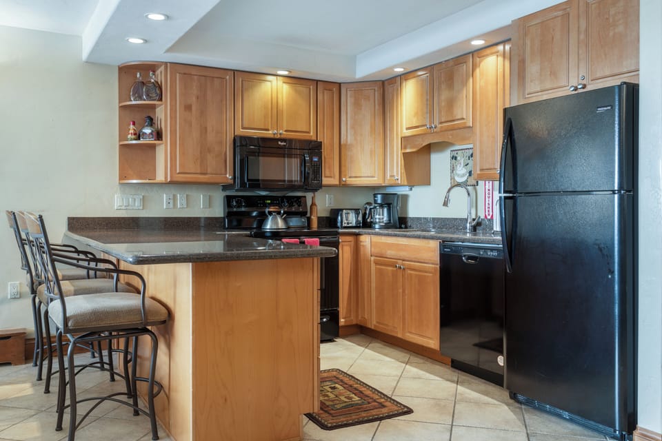 Fully stocked kitchen with granite countertops and bar seating for 3.