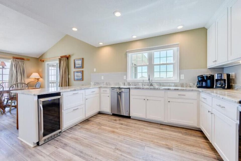 Prepare your favorite meals in this bright kitchen with gleaming white cabinetry, granite countertops, and modern stainless appliances. A warm space opens to the dining area, inviting you to gather and create memories over home-cooked dishes.