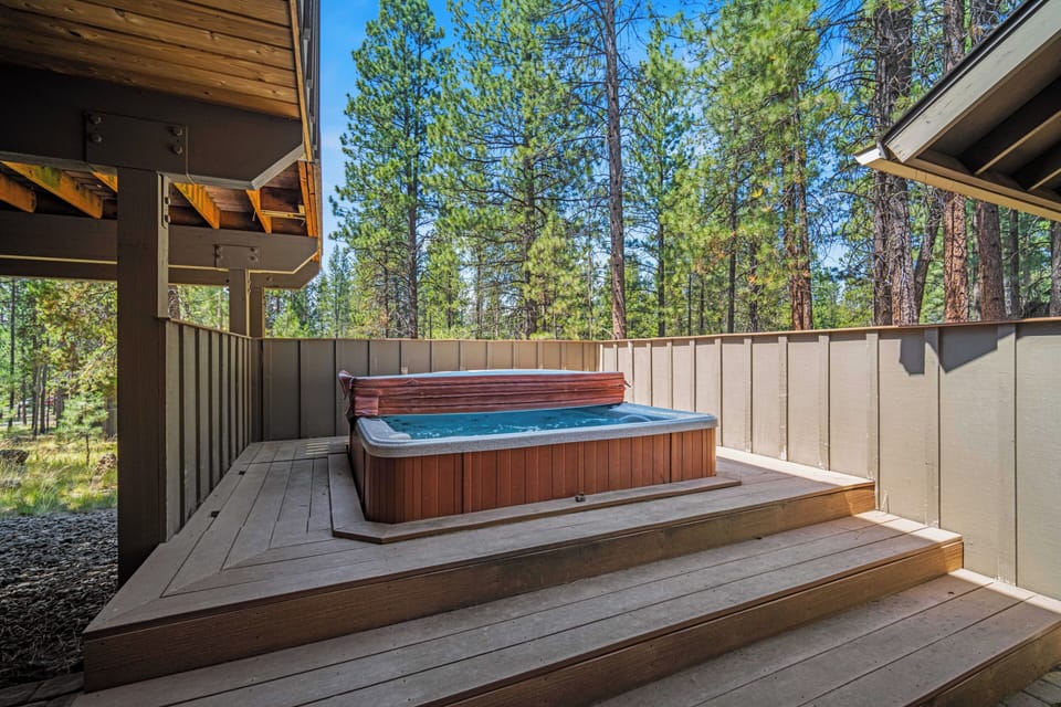 Soak in your private hot tub surrounded by towering pines—a serene escape under the open sky where relaxation and nature blend effortlessly.