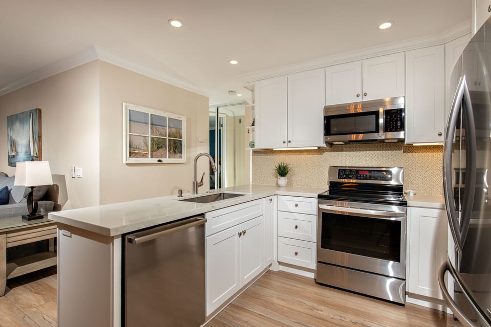 The kitchen is equipped with dishes, pots and pans,  and cooking utensils, blender, coffee pot, and toaster.