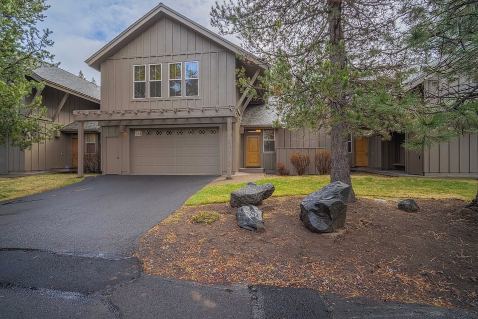 Modern mountain retreat with natural landscaping and convenient garage parking in a peaceful neighborhood setting.