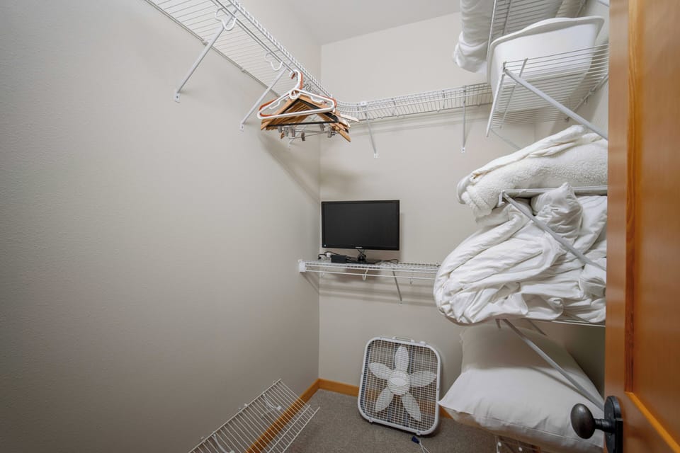 Your walk-in closet offers organized wire shelving, a mounted TV for getting ready, and ample space for all your belongings.