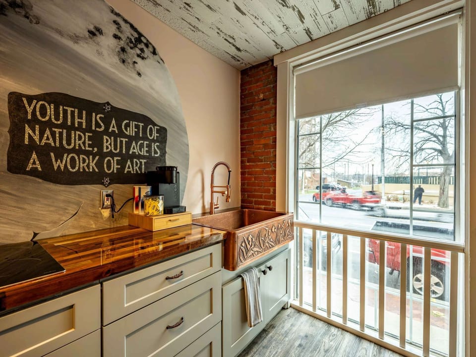 Window-side sink area w/ rustic décor &amp; natural light pouring into the kitchen