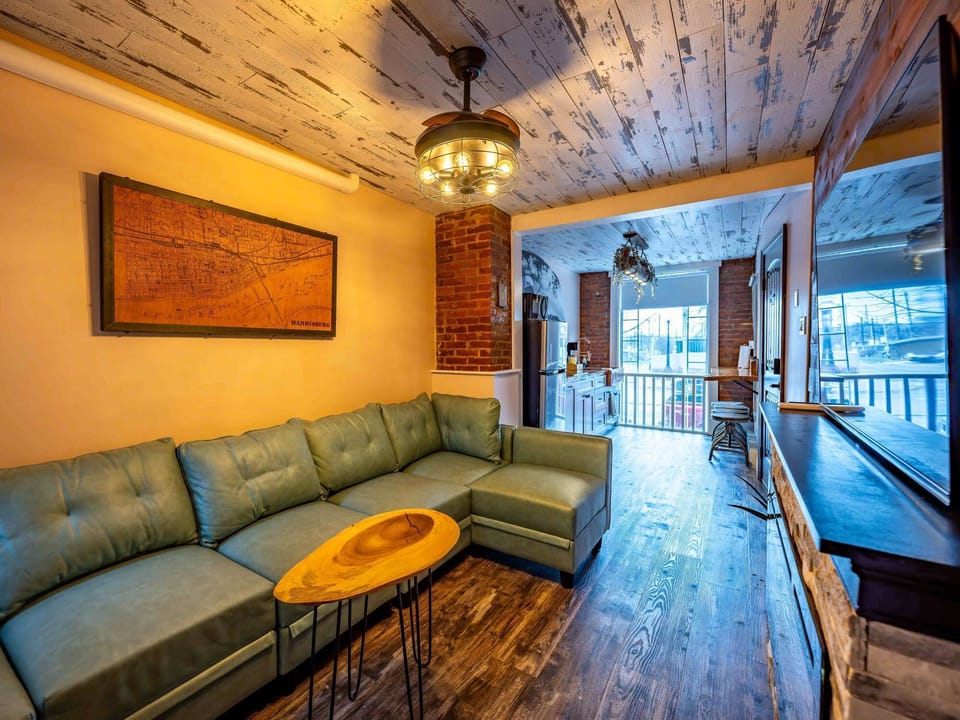 Bright lounge space w/ cozy seating, rustic ceilings &amp; sliding doors to the balcony