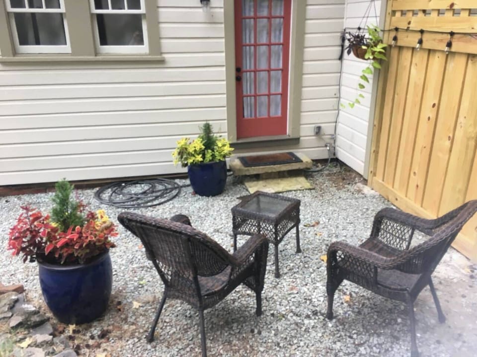 Private back patio accessible from Bedroom, surrounded by lush plants, and decorated with twinkling cafe lights