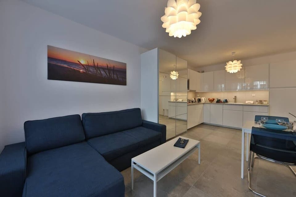 A living room with a gray couch, coffee table, and wall-mounted TV for a comfortable entertainment space.