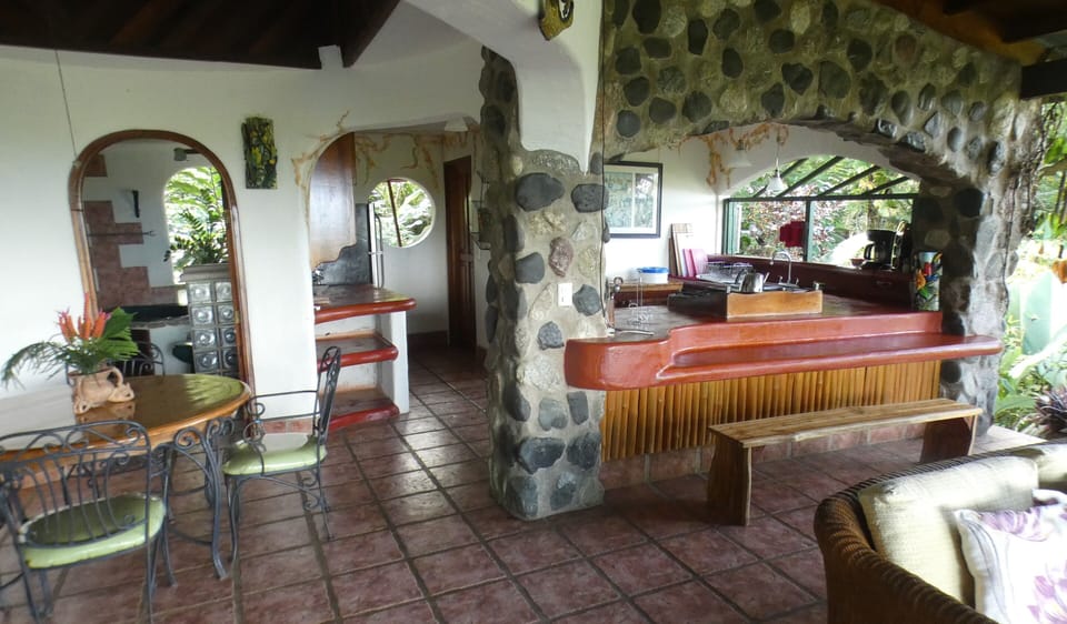 Open air living room with ocean view and monkeys in jungle