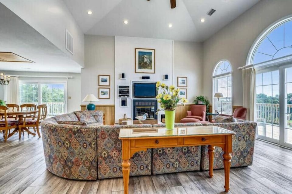 Step into your spacious living area where vaulted ceilings and natural light create an inviting atmosphere. Sink into plush seating while you enjoy mountain views through elegant arched windows.
