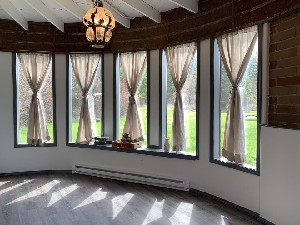 Sunshine cheerfully fills every room of the house w/ floor to ceiling windows. 