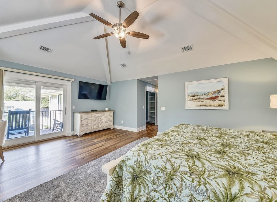 Master Bedroom with Mounted TV and Private Deck Overlooking Pool at 29 Pelican