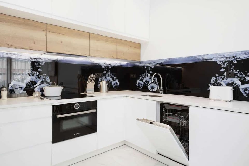 A sleek kitchenette with white cabinetry, minimalist design, and dark countertops for a contrasting look.