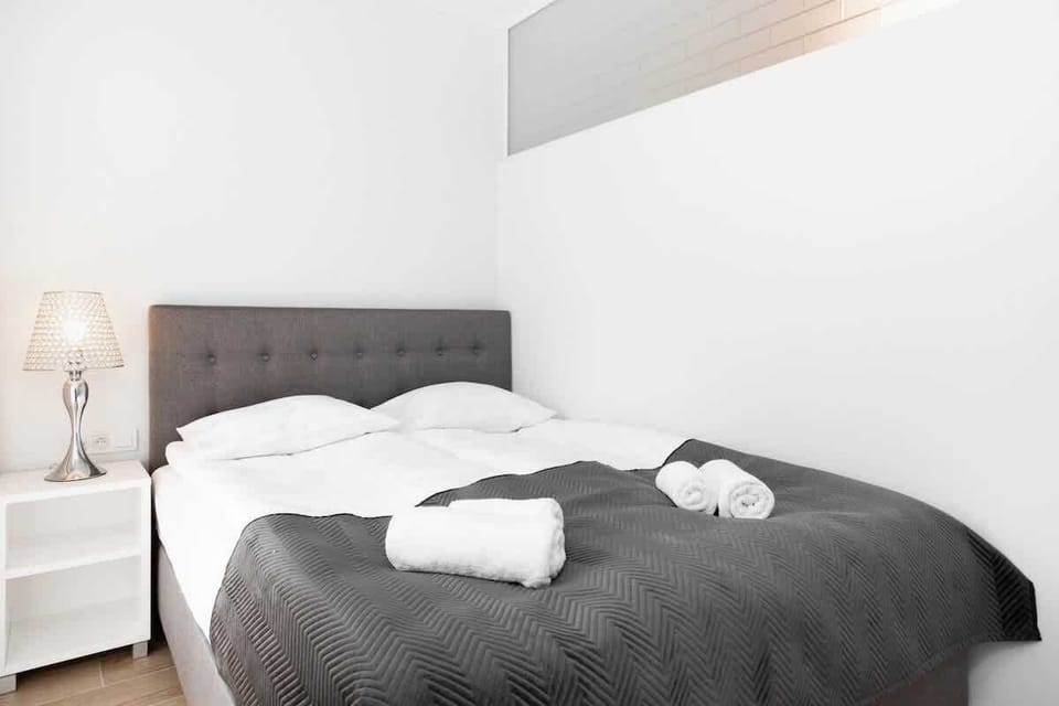 Another bedroom featuring a cozy bed with white bedding and a simple, minimalist decor style.