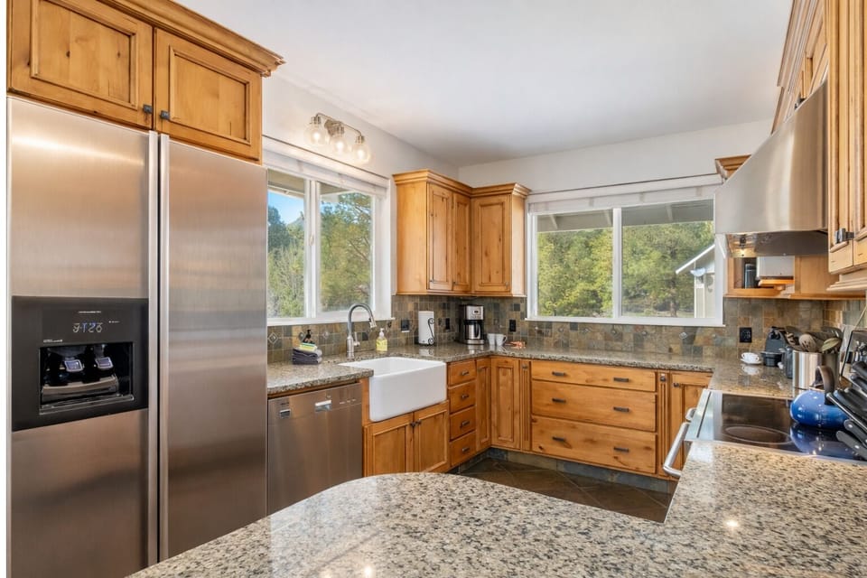 You'll love cooking in this spacious kitchen with granite counters, stainless appliances, and peaceful forest views through every window.