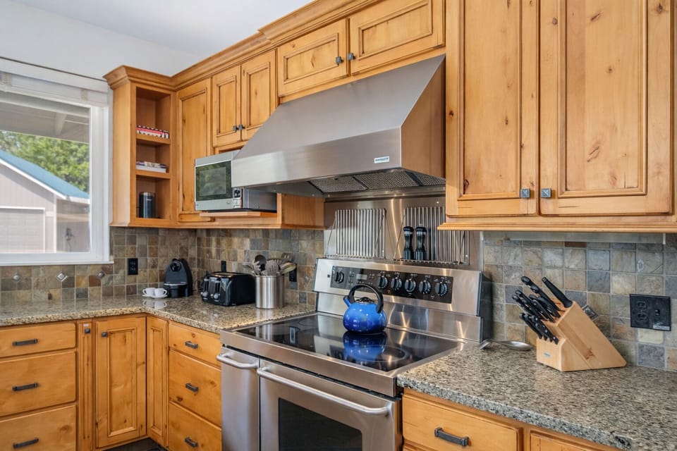 Your fully equipped kitchen features granite countertops, custom wood cabinetry, and professional-grade appliances perfect for preparing memorable meals during your stay.