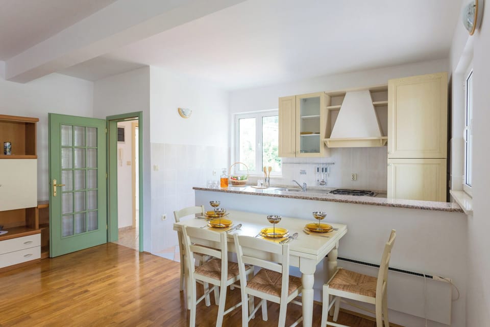 Gather for a meal in the bright, open-plan dining area, featuring a well-equipped kitchen perfect for preparing local delicacies.