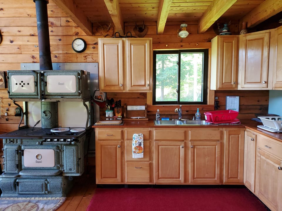 Kitchen area, gas stove with woodstove in it.