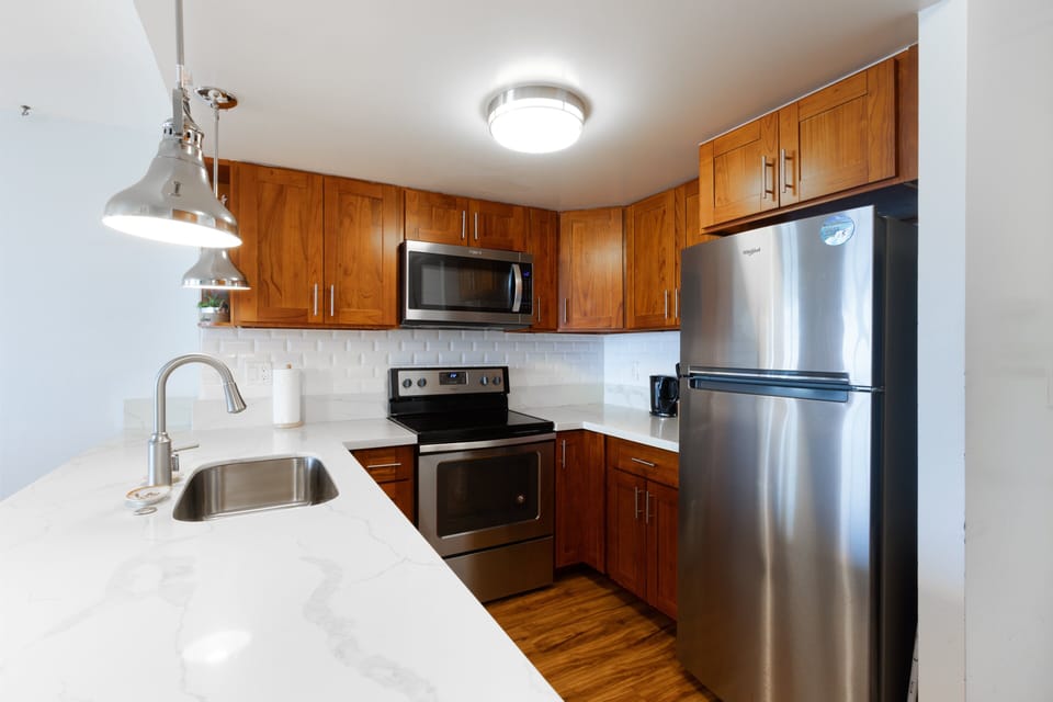 Fully equipped kitchen with stainless-steel appliances and quartz countertops