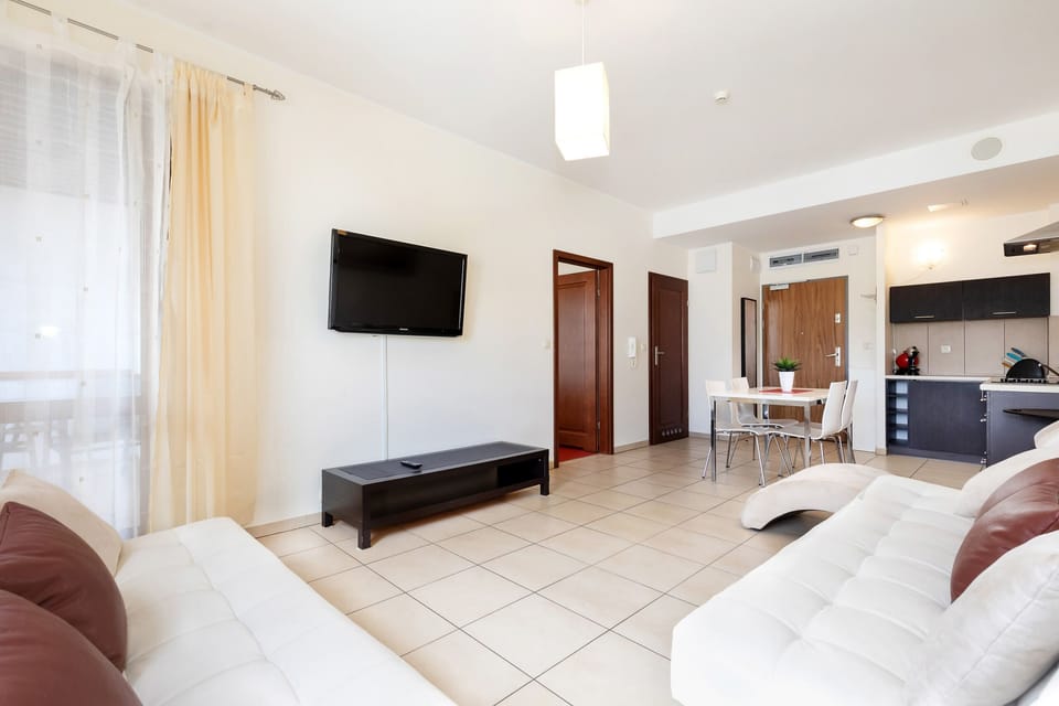 Another view of the living room, showcasing the spacious layout with large windows allowing ample natural light.