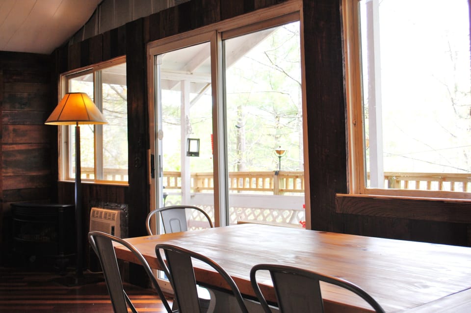 Large solid wood farm table in main level living area of cabin.