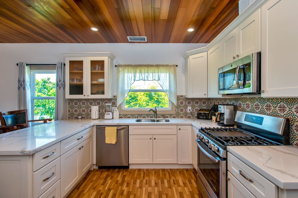 Kitchen with gas stove, built in microwave oven, quartz countertop, dishwasher.