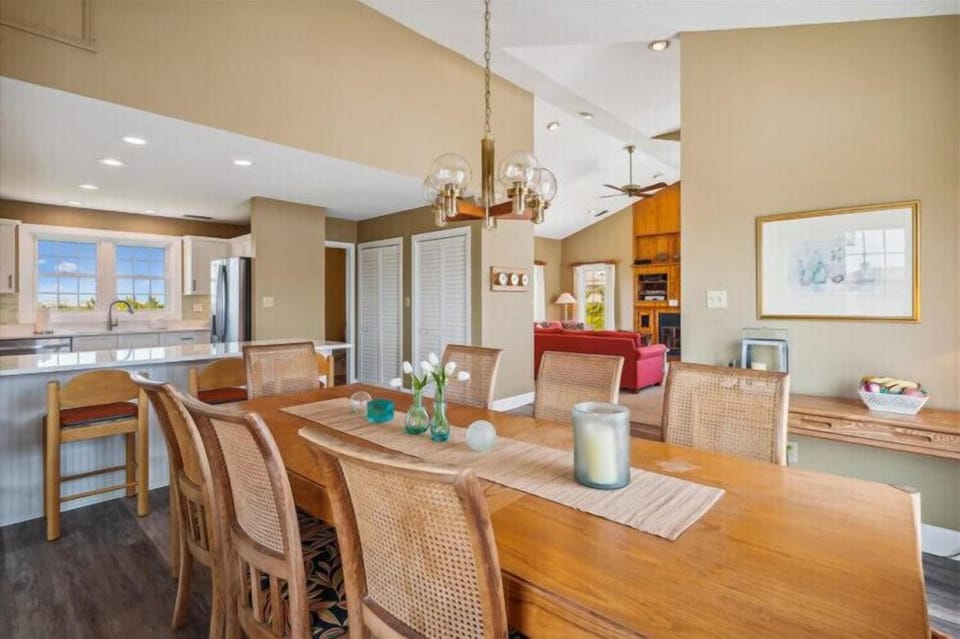 Picture yourself gathering around this inviting dining table, where natural light fills the open-concept space and connects you to a fully-equipped kitchen, perfect for shared meals and memories.