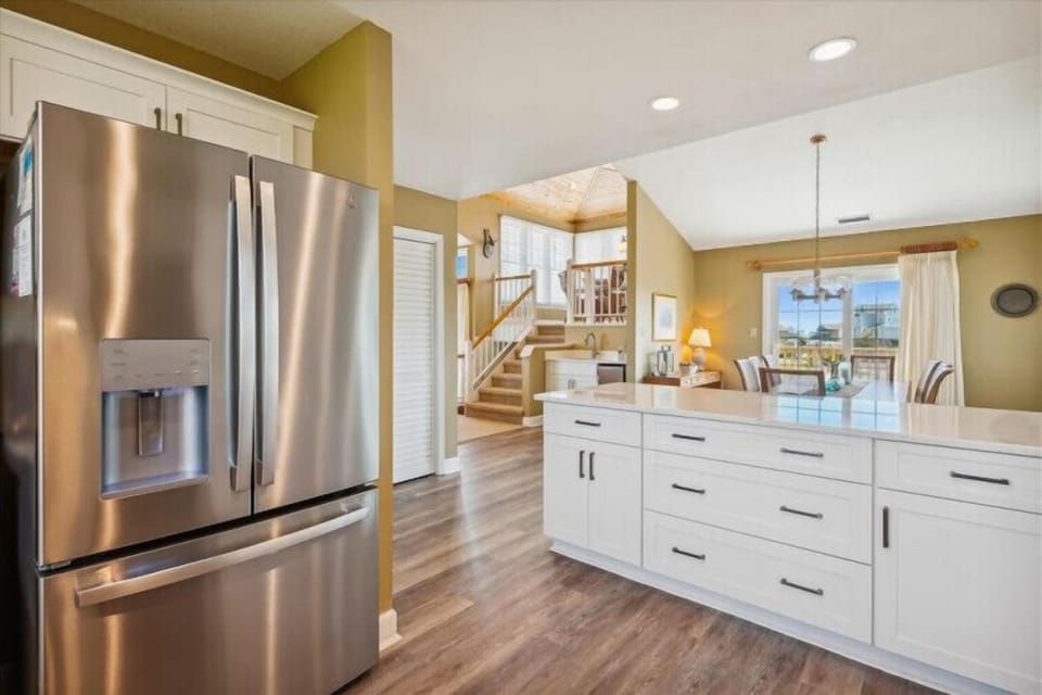 Step into your open-plan retreat where a modern kitchen flows seamlessly into bright living spaces. Vaulted ceilings and warm natural light create an inviting atmosphere for your vacation stay.