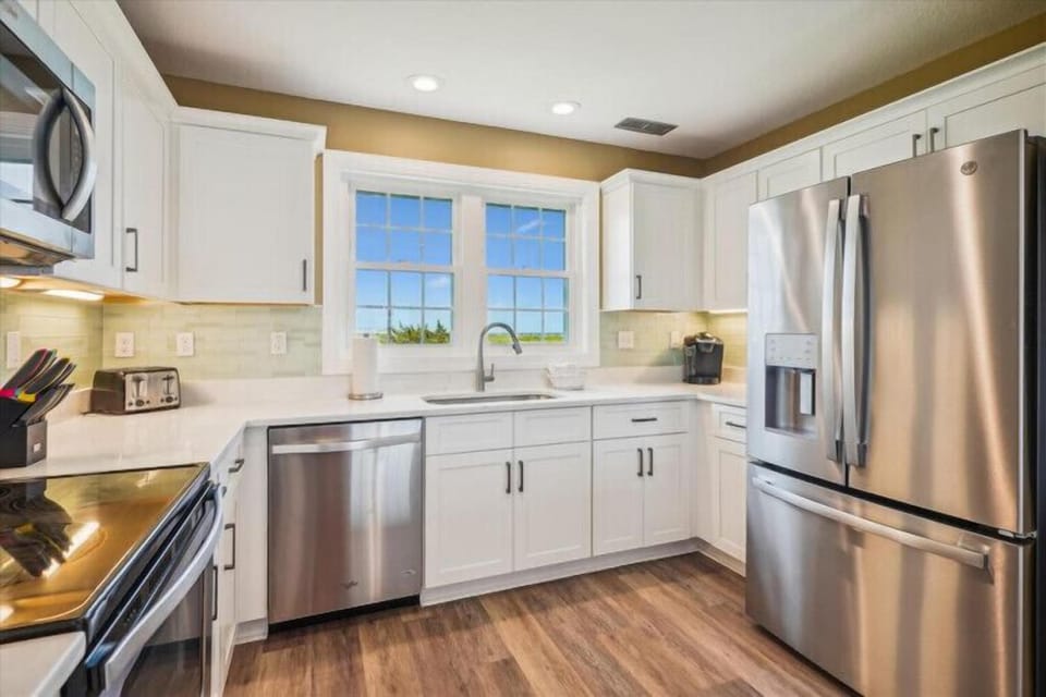 This bright, fully equipped kitchen makes preparing your favorite meals a breeze, with stainless steel appliances, plenty of counter space, and windows that frame a peaceful water view.