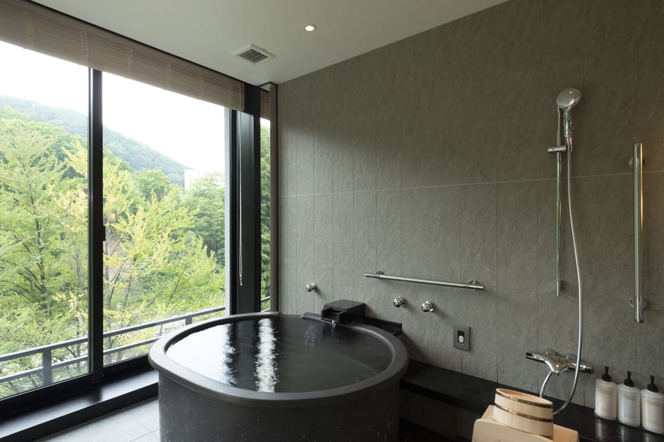 Deluxe Corner Suite | Bathroom | Separate tub and shower, spring water tub, free toiletries, hair dryer