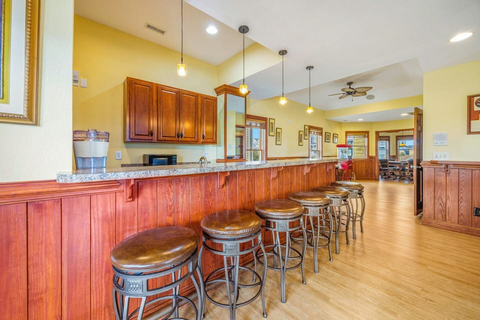 Your spacious kitchen features a stunning granite island with leather bar seating, perfect for casual meals and morning coffee conversations.
