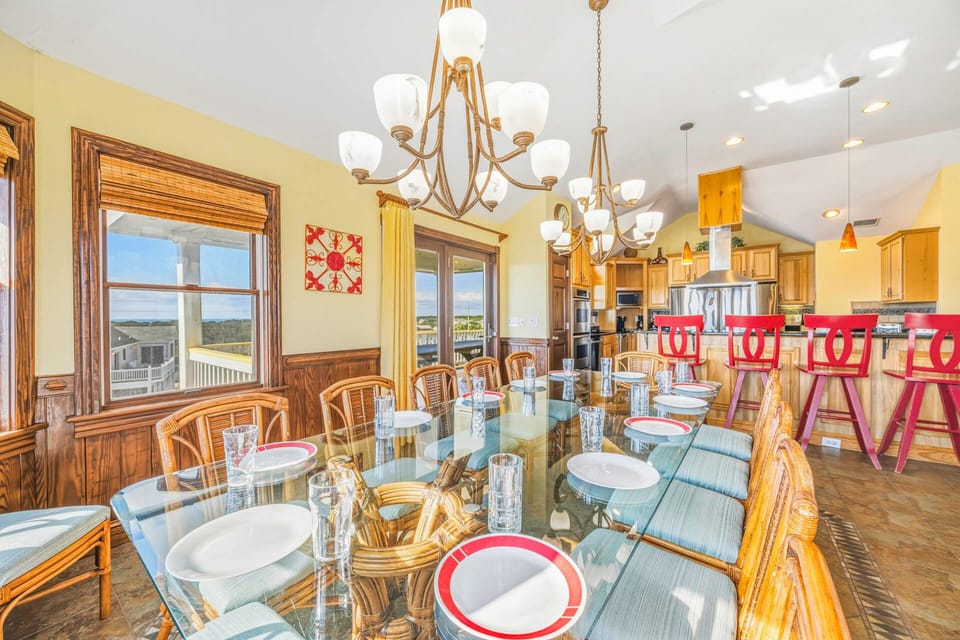 Gather around this elegant dining table where memorable meals unfold beneath stunning chandeliers, with kitchen convenience just steps away.