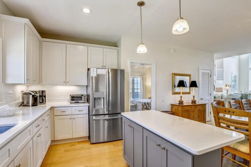 Your spacious, light-filled kitchen features stainless steel appliances, a large island for prep and gathering, and pendant lighting overhead. Everything you need to create memorable meals awaits.