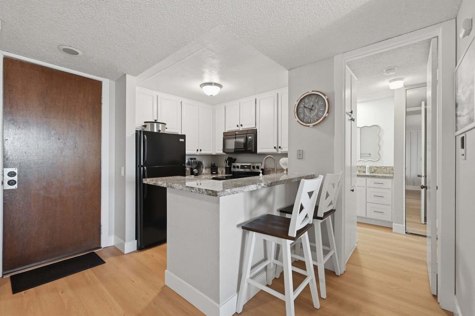 Featuring a pair of stylish stools tucked neatly at the kitchen island, this space serves as the perfect spot for a quick morning coffee or keeping the designated "chef" company while they work.