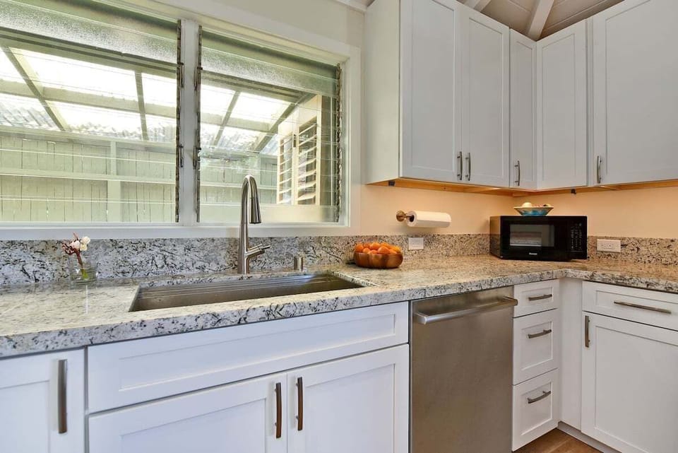 Spacious kitchen with large window, ample counter space, and contemporary design.