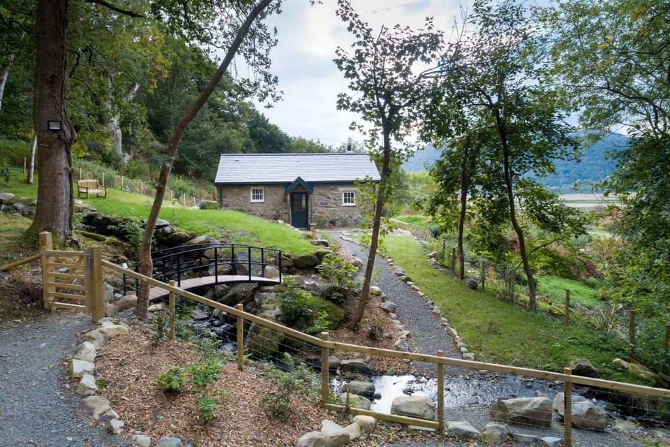 This detached cottage lies on its own off a woodland track with a pretty stream tumbling past