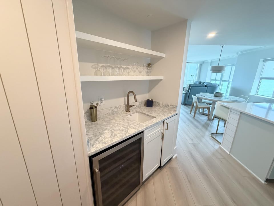 Sleek wet bar with wine fridge and marble countertop