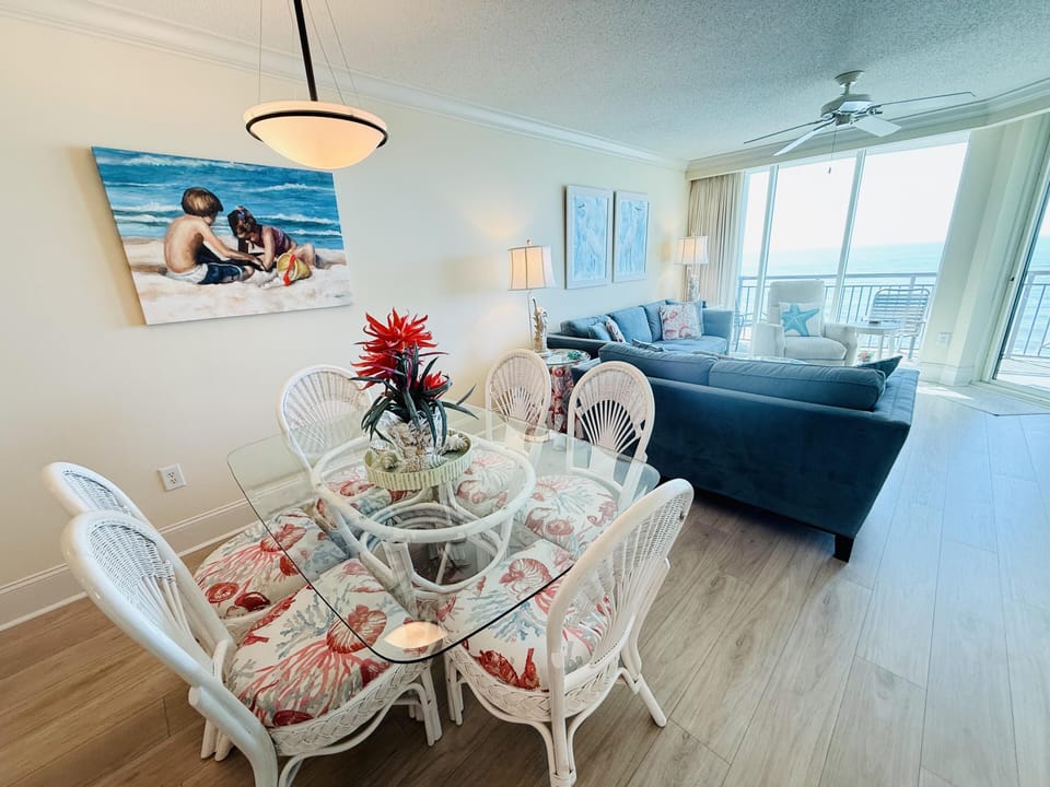 Bright dining and living area with ocean views and cozy seating